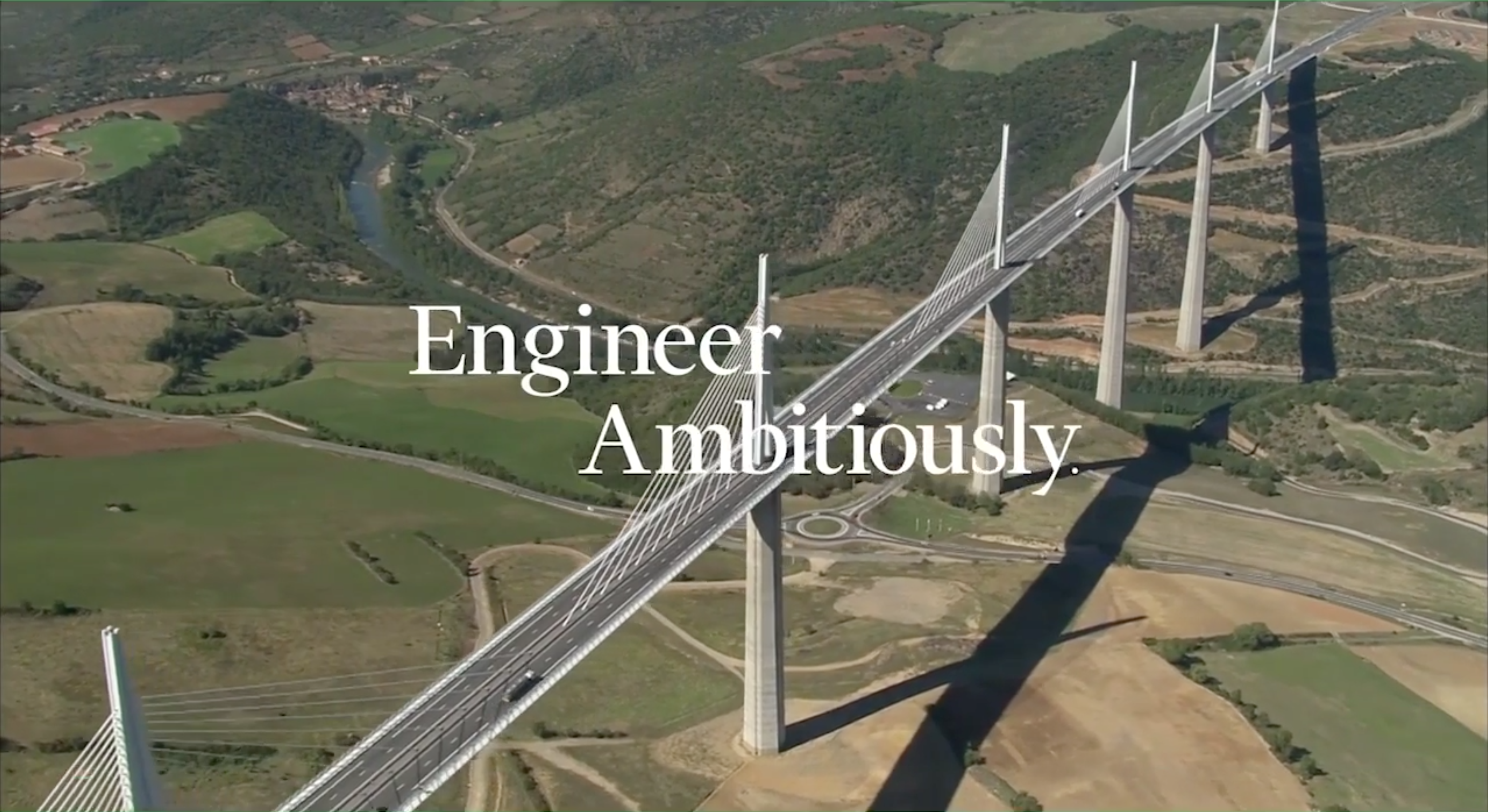 Aerial shot of a large brigde over a vast grassy land with the words Engineer Ambitiously written across the image