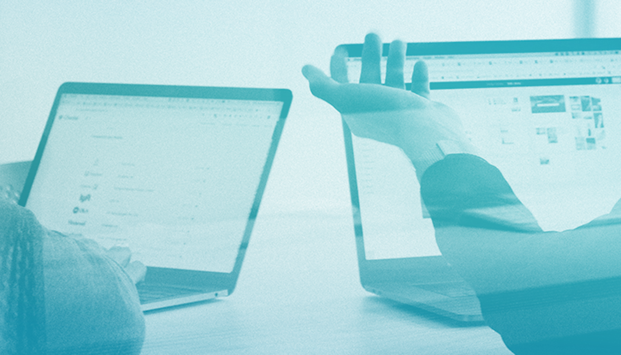 Forearm and hand gesturing to two laptops